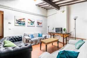 Un salon avec un canapé, une table basse et des œuvres d’art accrochées au mur.
