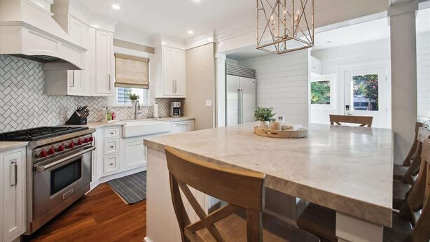 A modern kitchen with white cabinetry, a central island, and a built-in oven. - Downtown Annapolis Duke's House (Annapolis)