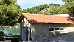 A building with a tiled roof, a door, and a small window.