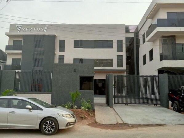 A modern building with a sign reading "VERTUS". - Vertus Hotel and Suites  (Benin City)