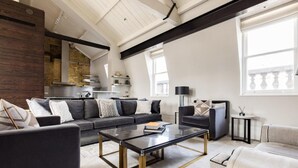 A modern living room with a sofa, coffee table, and a fireplace. - Penthouse Luxury in Covent Garden (London)