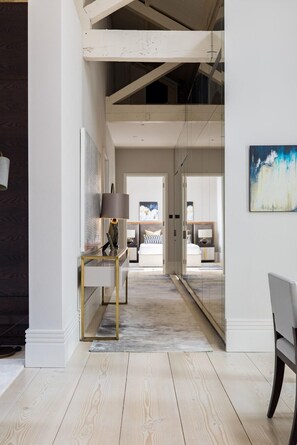 A modern interior with a desk, lamp, and a bed in the background. - Penthouse Luxury in Covent Garden (London)