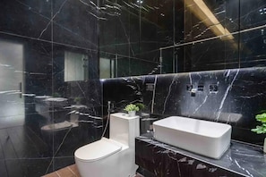 A modern bathroom with black marble walls, a white toilet, and a white sink. - DO NOT Book Invalid Listing (Bangkok)