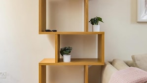 A multi-tiered wooden shelf unit with two potted plants on different levels. - Designer Muji Home by Harrods (London)