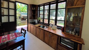 A kitchen with wooden cabinets, a built-in oven, and a window overlooking a garden.