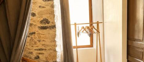 A wooden staircase leading to a loft area with a wooden drying rack and a window.