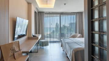 Habitación doble Deluxe, balcón, vista parcial al mar | 1 habitación, minibar, caja de seguridad en la habitación y escritorio