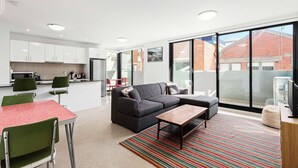 A modern apartment with a kitchen, dining area, and living room.