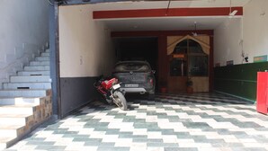 Un garaje con piso a cuadros, un SUV estacionado y una motocicleta.