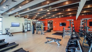 Un gimnasio con cintas de correr, máquinas de pesas y un saco de boxeo.