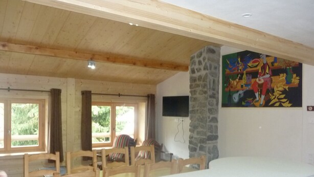 Una habitación amplia con techo alto, un pilar de piedra y un mural de colores en la pared.