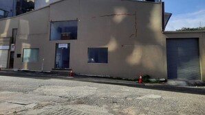 A building with a flat roof, a large window, and a closed garage door. - Island Inn Colombo00 (Colombo)