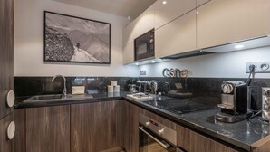 A modern kitchen with a built-in oven, a microwave, and a coffee machine. - Modern 2-Bedroom Apartment in Morzine Center with Parking and Wifi (Morzine)