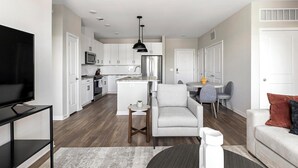 Een modern appartement met keuken, eethoek en woonkamer.