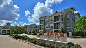 A multi-story apartment building with a sign reading 'The Grayson Luxury Apartments.'