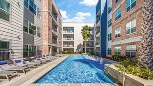 A pool area with lounge chairs and a no-diving sign. - Landing | Beautiful 2BD, Yoga Studio, Clubhouse (San Antonio)
