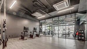 A modern gym with exercise bikes, weight machines, and kettlebells. - Landing | Incredible 1BD, Yoga Studio, Gym (Salt Lake City)