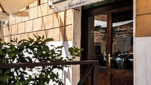 A storefront with a sign reading "Assuntina" and a wooden door. - Testaccio Design Apartment in Rome - to feel the authentic vibe! (Roma)
