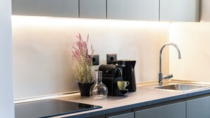 A modern kitchen with a built-in stove, a coffee maker, and a sink. - Testaccio Design Apartment in Rome - to feel the authentic vibe! (Roma)
