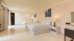 Habitación de hotel con una cama grande, mesitas de noche, un espejo y un cuadro en la pared.