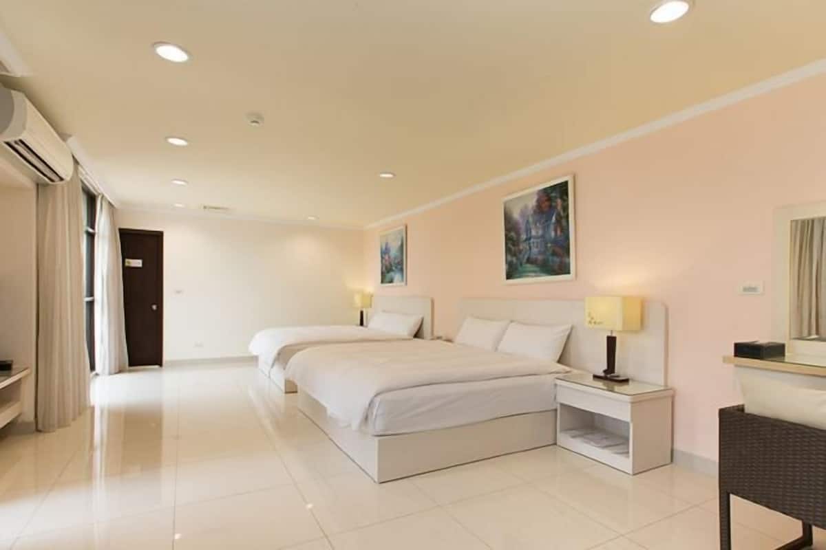 Habitación de hotel con una cama grande, mesitas de noche, un espejo y un cuadro en la pared.