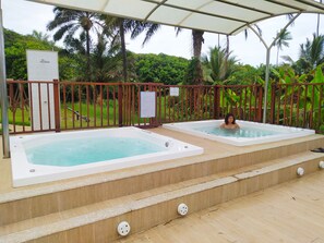 A pool area with two hot tubs, surrounded by a wooden deck and a metal fence. - Ilhéus North Residence (Uruçuca)
