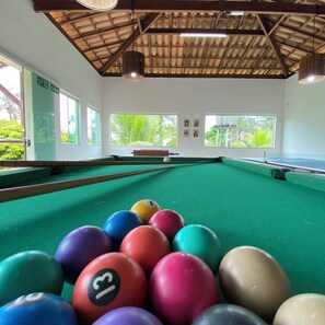 A pool table with a green felt surface and colorful balls in the foreground. - Ilhéus North Residence (Uruçuca)