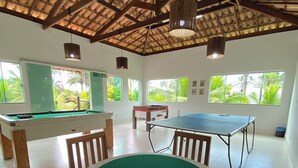 Una habitación con mesa de billar, mesa de futbolín y mesa de billares.