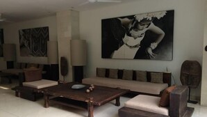 Un salon moderne avec un canapé, une table basse et des œuvres d’art accrochées au mur.