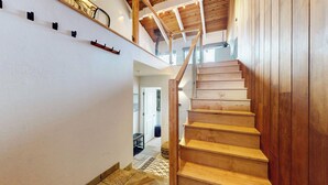 A wooden staircase leading to an upper floor with a glass railing and a wooden ceiling. - Chic Home With Stunning Views! Modern & Natural Light, Private Washer/Dryer (Mammoth Lakes)