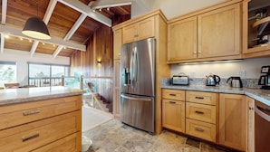 A modern kitchen with wooden cabinets, a stainless steel refrigerator, a built-in toaster, and a coffee maker. - Chic Home With Stunning Views! Modern & Natural Light, Private Washer/Dryer (Mammoth Lakes)