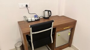 A compact kitchenette with a coffee maker, a kettle, and a small fridge. - Hotel Sun Flowers (Alwar)