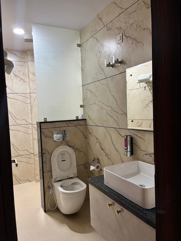 A modern bathroom with a toilet, bidet, and sink.