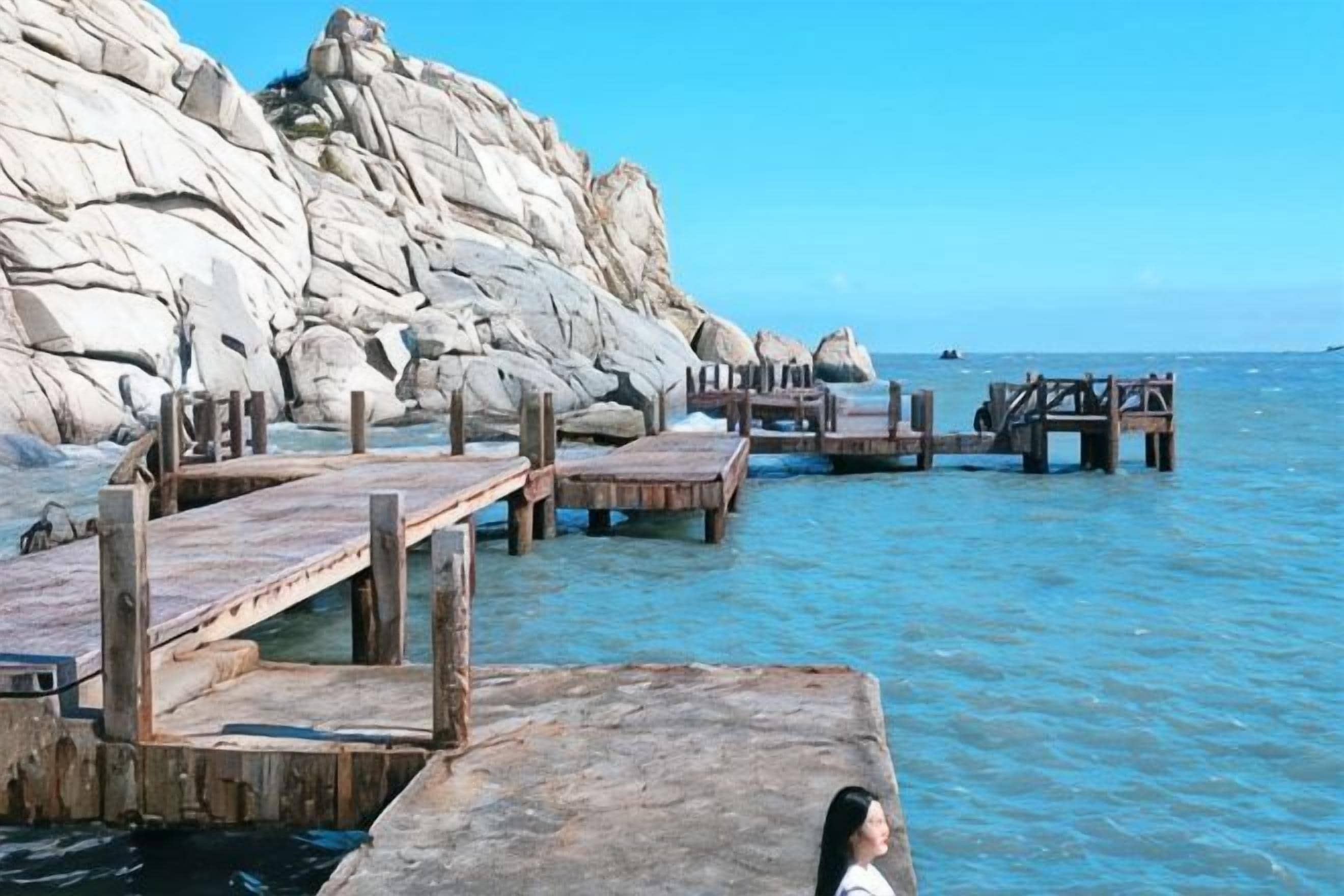 A rocky coastline with wooden walkways leading into the water.