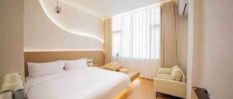 Una habitación de hotel moderna con una cama grande, mesitas de noche, un sofá y una ventana con cortinas.