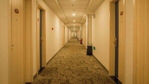 A long, narrow hotel corridor with carpeted floors and doors on both sides. - Elan Hotel (Yantai Muping Bus Station) (Yantai)