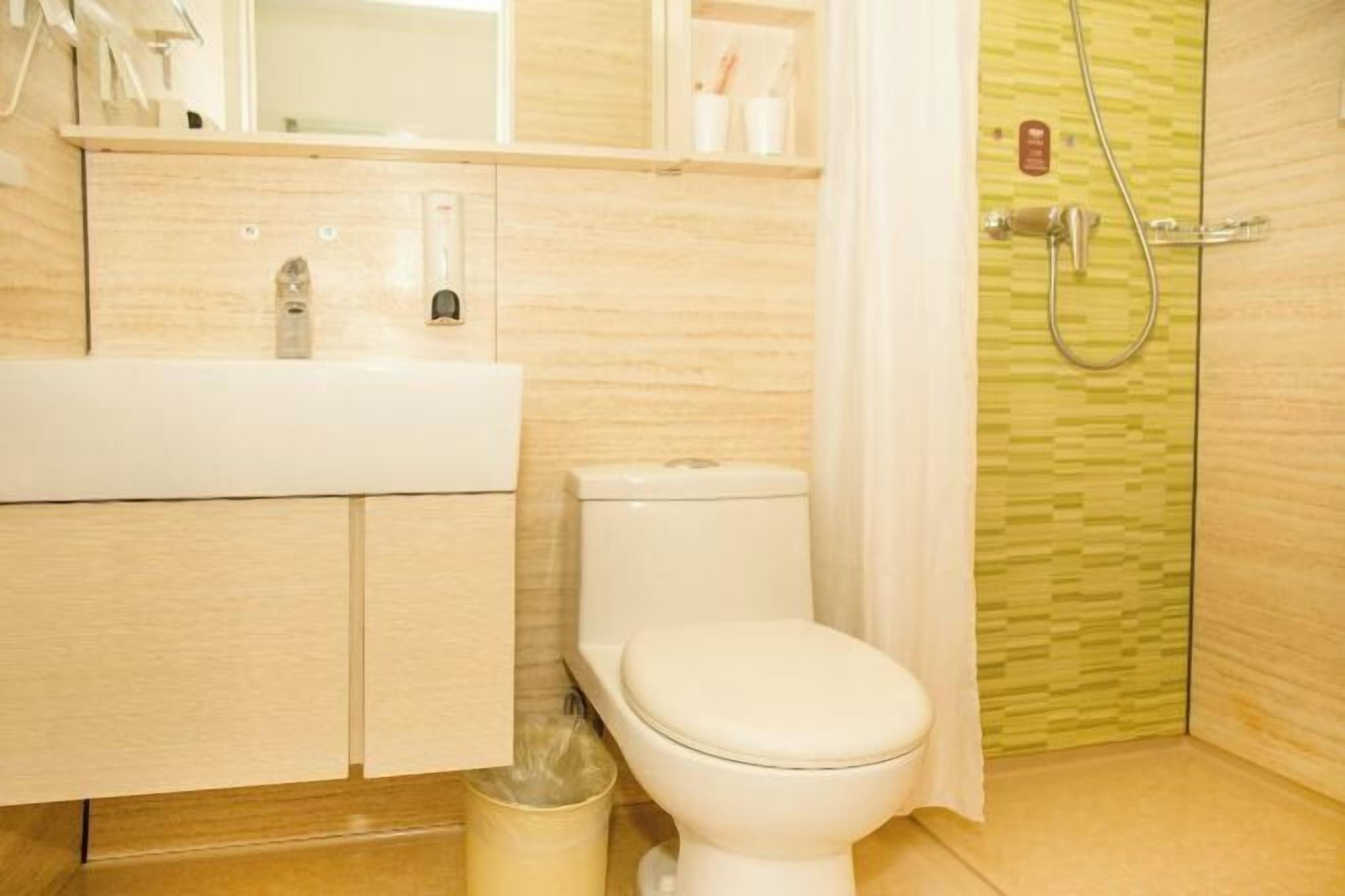A bathroom with a white sink, toilet, and shower area.