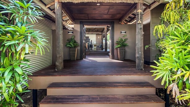 A covered walkway leading to a building with a wooden floor and steps. - Banyak Villa (Horseshoe Bay)