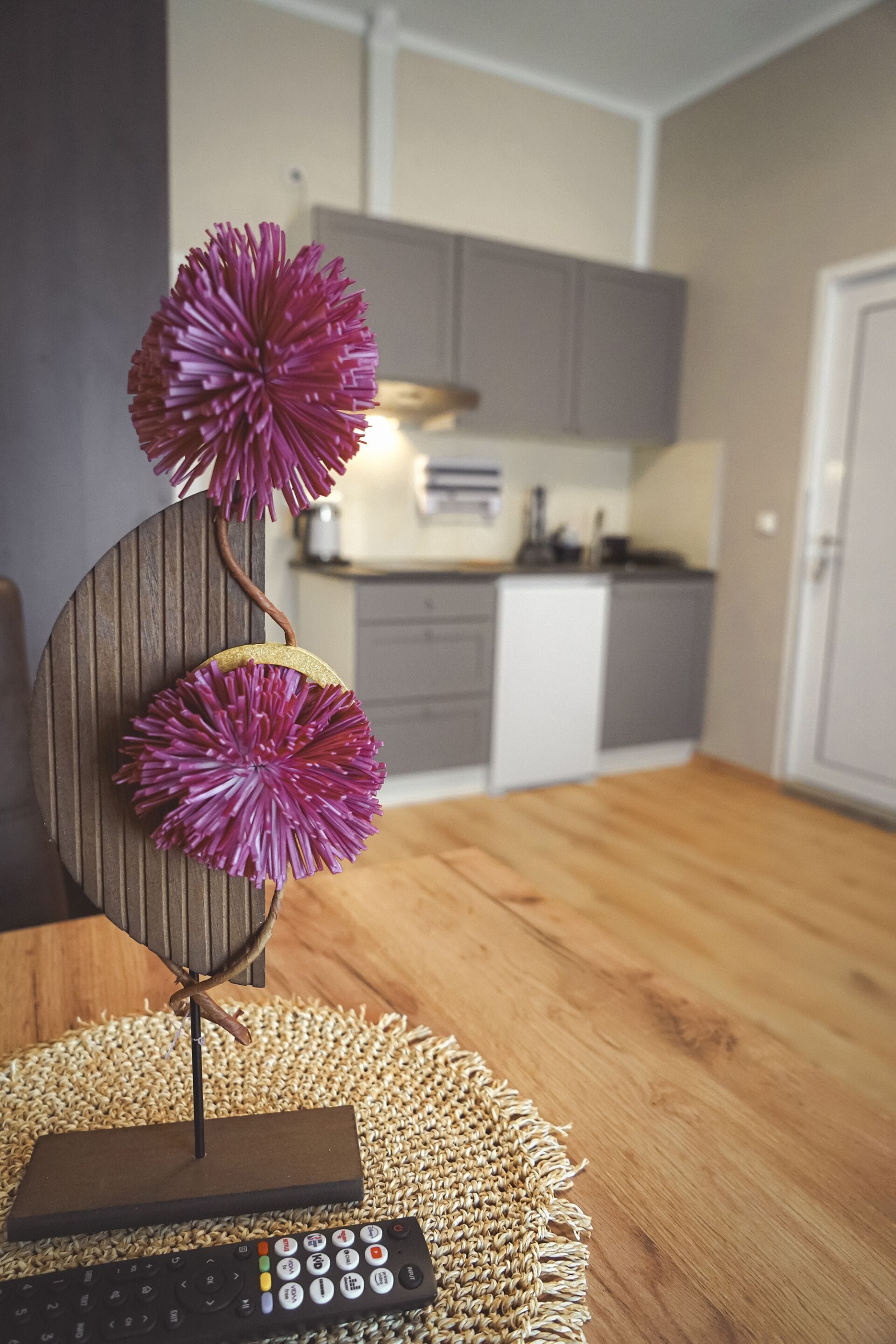 Una mesa de comedor con un control remoto y un adorno decorativo.