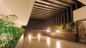 A corridor with patterned flooring, green plants, and a ceiling with a geometric design. - mannat residency by io hotels (Amritsar)