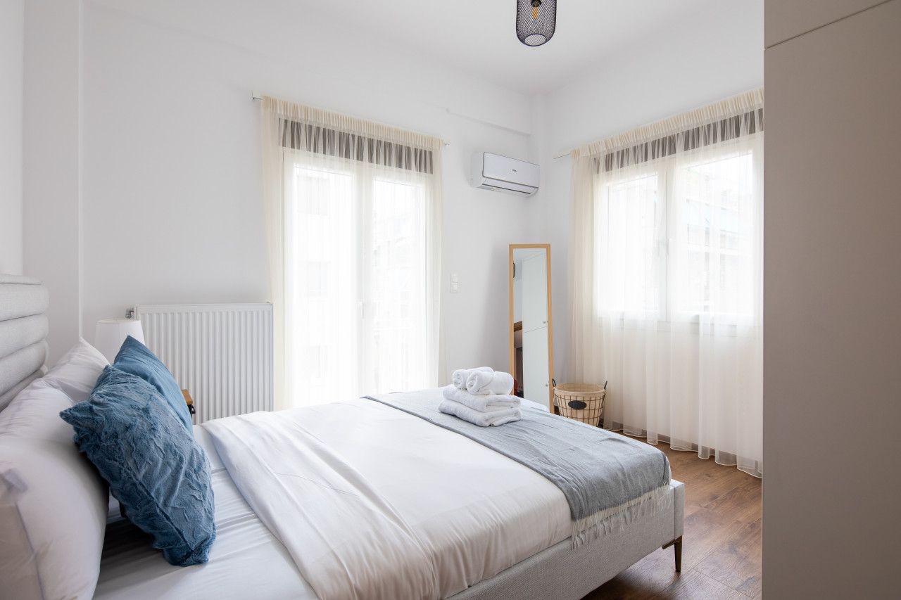 Et soveværelse med seng, spejl og radiator.