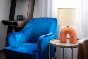 A blue armchair next to a round table with a lamp. - Alex’s 2-Bedroom Apartment in Athens (Greece - Athens)