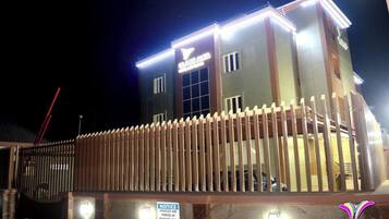 Vista frontal de la propiedad por la tarde o noche