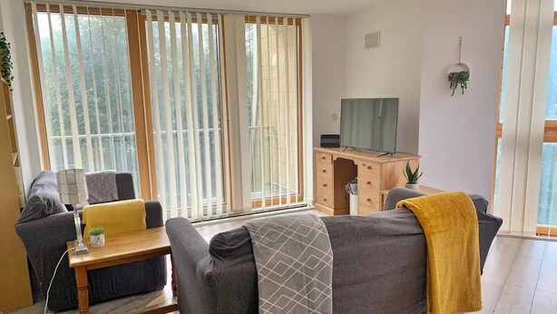 Ein modernes Wohnzimmer mit einer Couch, einem Couchtisch und einem Fernseher.