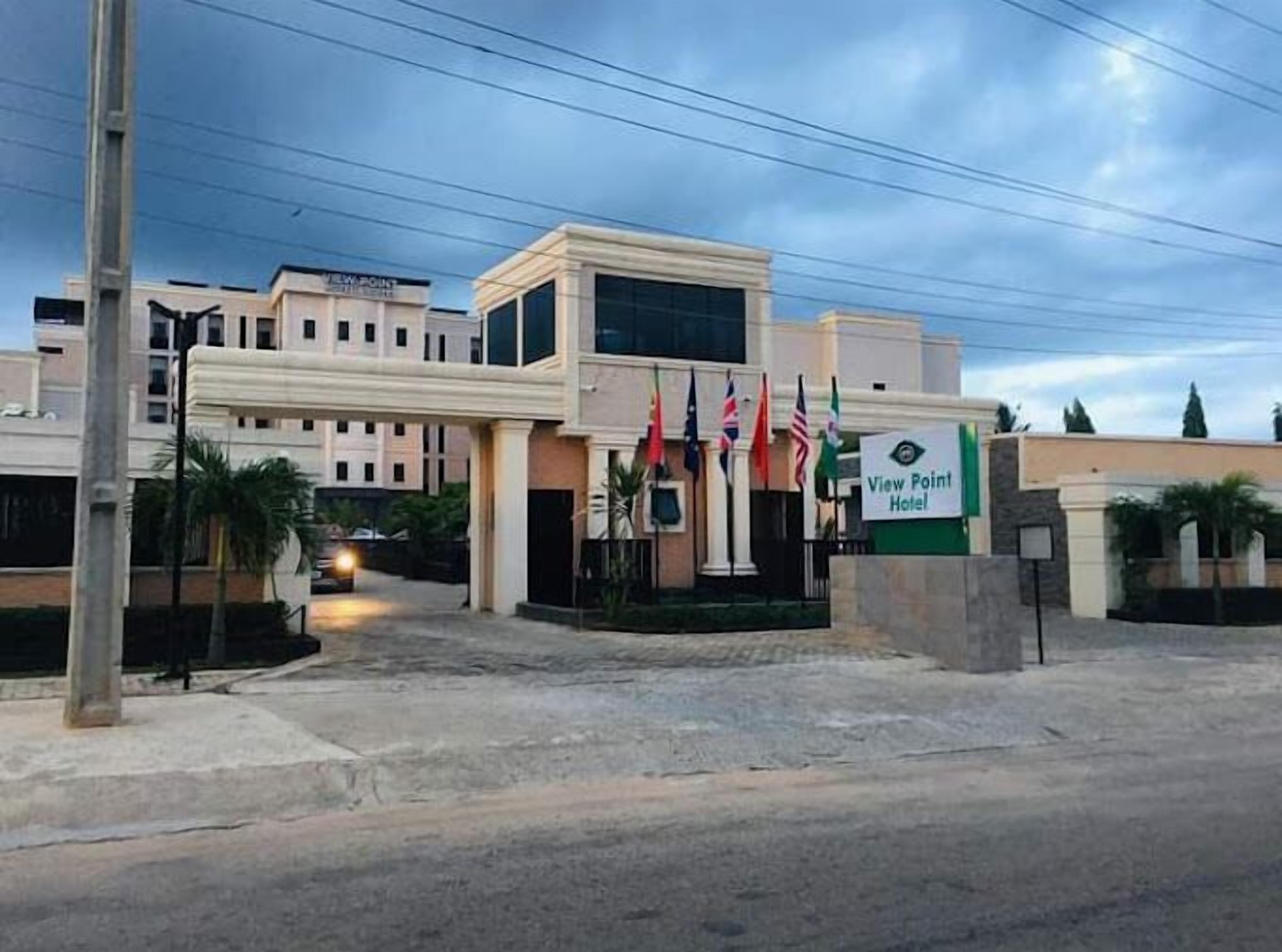 The exterior of the View Point Hotel with a modern architectural design, multiple flags, and a well-maintained entrance area.