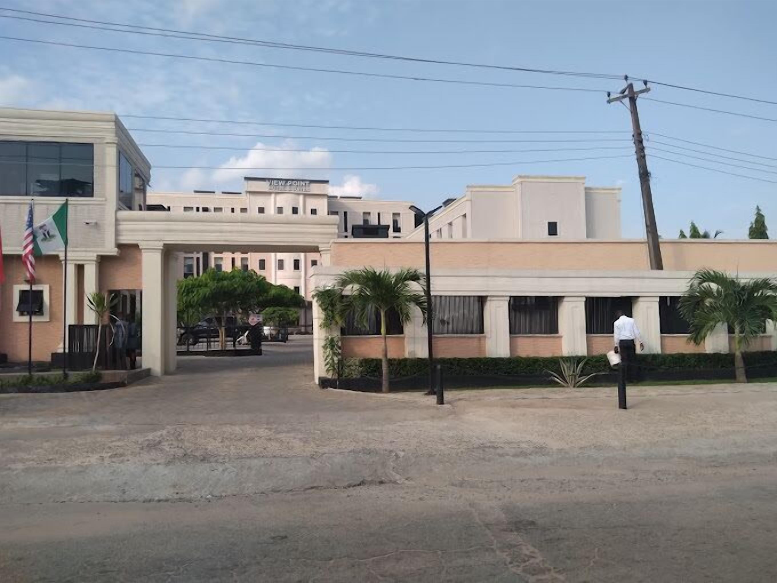 A hotel entrance with a modern design, including a covered driveway and palm trees.