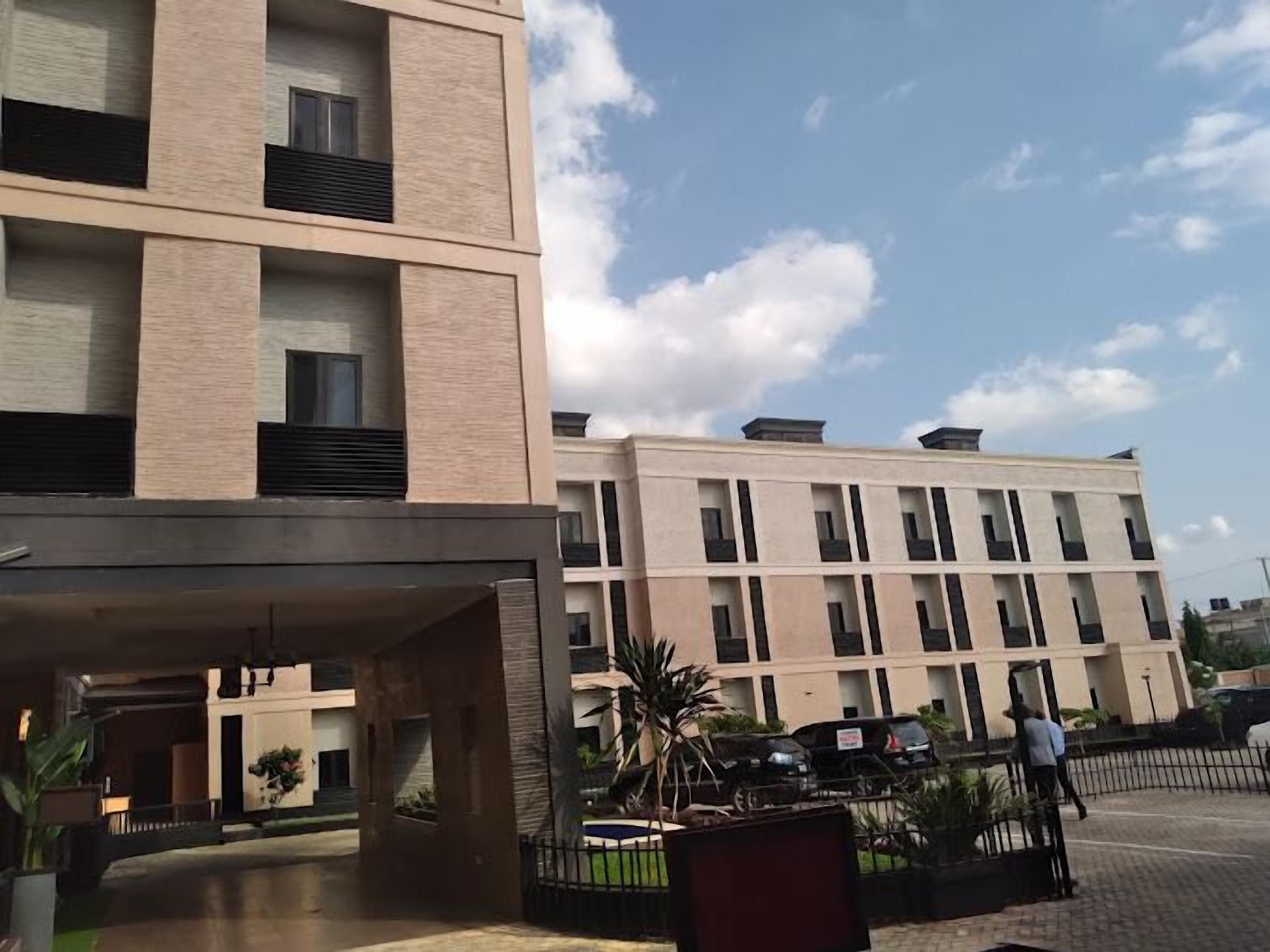 Un immeuble à plusieurs étages doté d’une architecture moderne, avec une série de balcons et un espace d’entrée abrité.