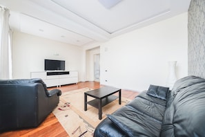 Apartamento, balcón, vistas a la ciudad | Zona de estar | Televisión LCD de 39 pulgadas con canales por cable