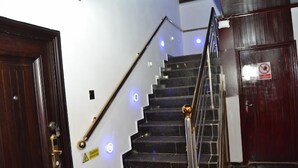 A staircase with a handrail, a caution sign, and a no-smoking sign. - La VOD Hotel (Benin City)