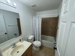 Een badkamer met een wastafel, toilet en bad.